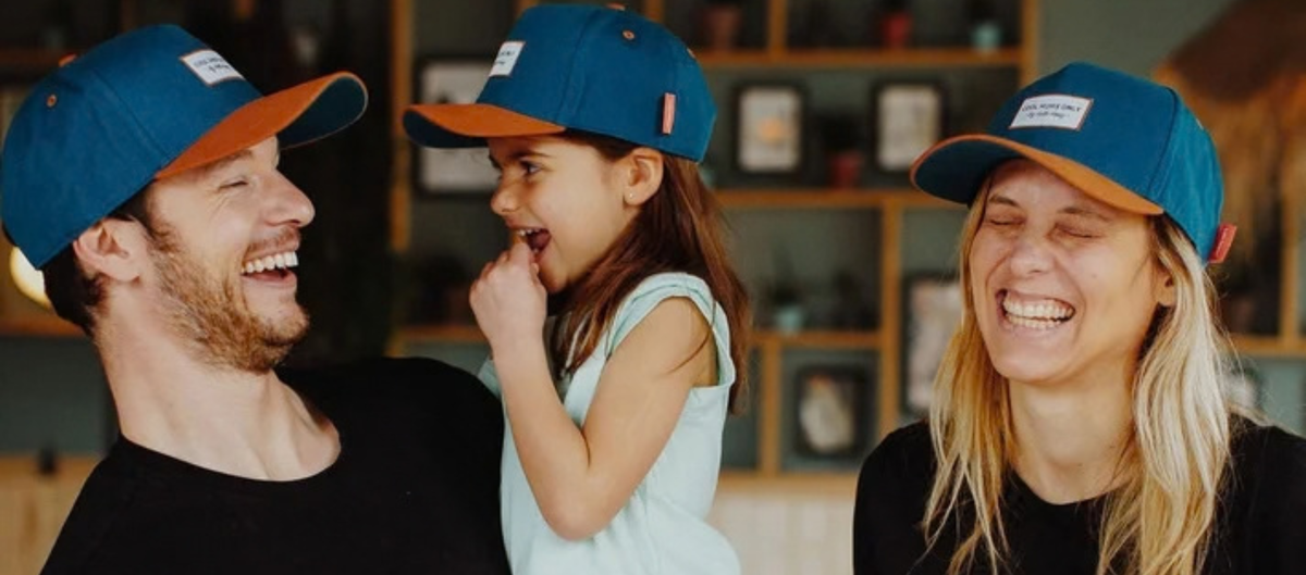 Family in matching blue caps smiling together