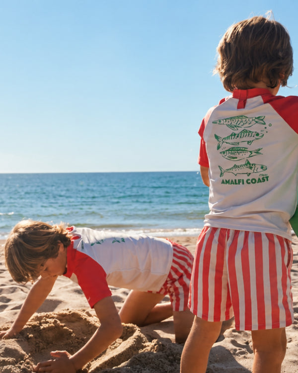 Kids in matching swimwear playing on the beach