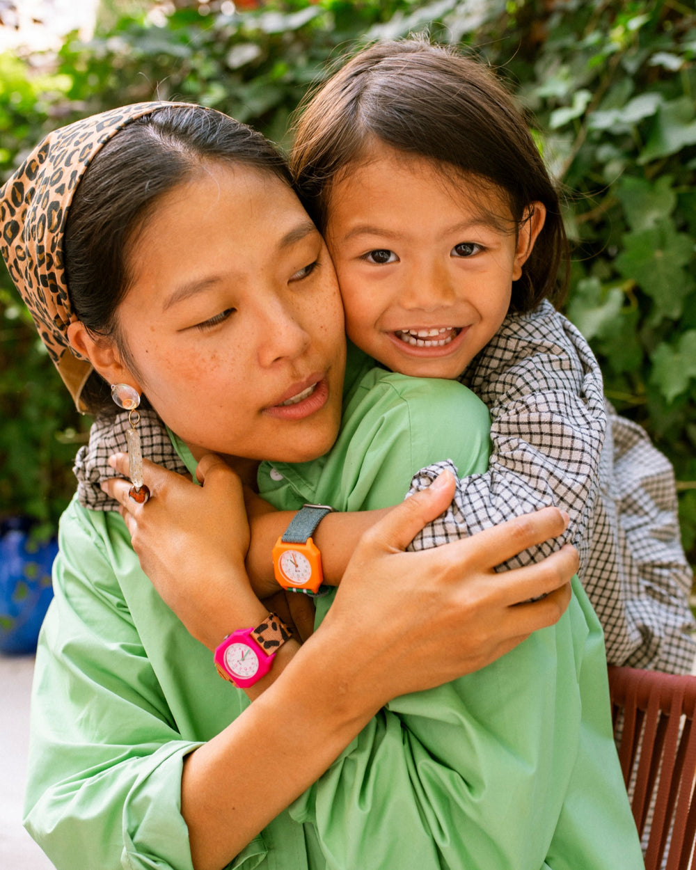 Mother and child hugging, wearing matching watches