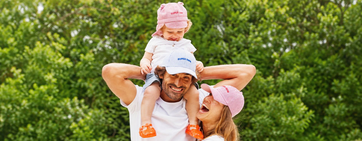 Dad, mum and child wearing matching Chamaye caps