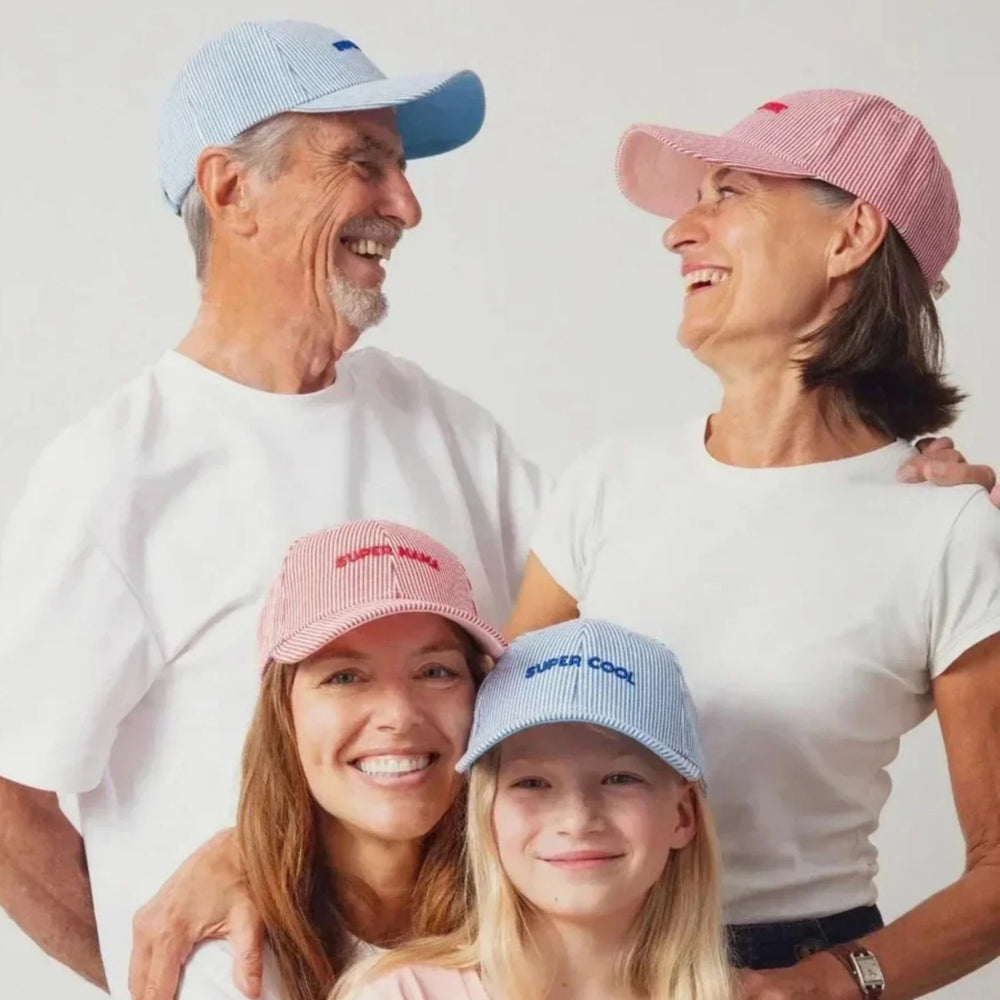 Grandparents, mother and daughter smiling in matching caps